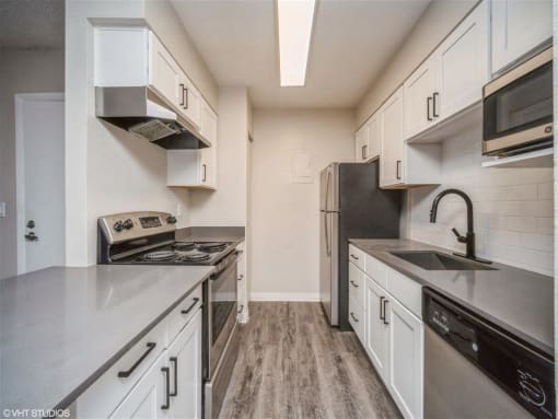 Kitchen with stainless steel appliances and white cabinets  at Avery Park in Englewood, CO
