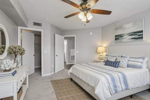 A bedroom with a bed, dresser, and mirror.