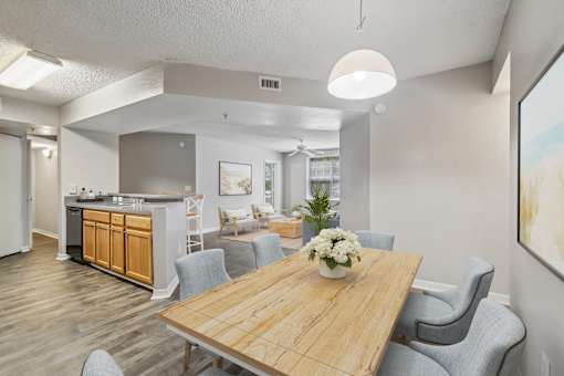 A dining room with a wooden table and grey chairs.