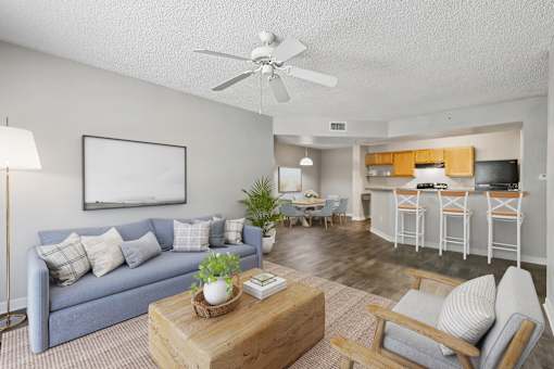 A living room with a blue couch and a wooden coffee table.