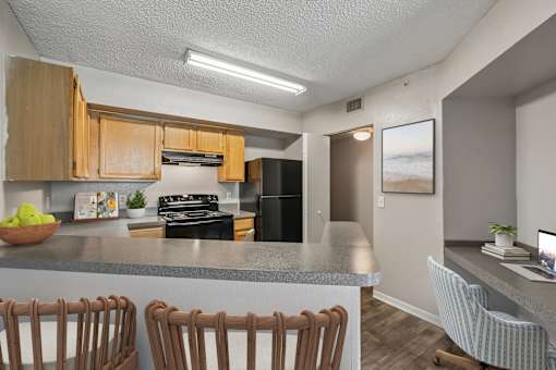 A kitchen with wooden cabinets and a grey countertop.