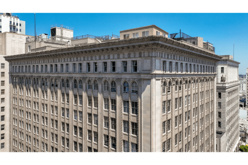 a tall building with many windows and a blue sky
