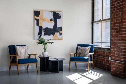 two chairs and a table in a room with a brick wall