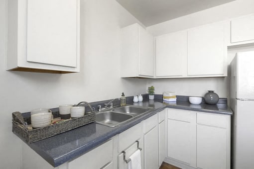 a kitchen with white cabinets and a stainless steel sink