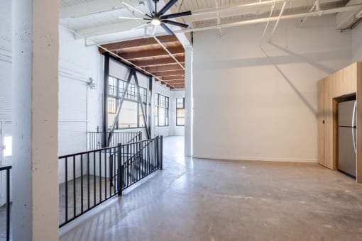 the lobby of a building with a concrete floor and white walls