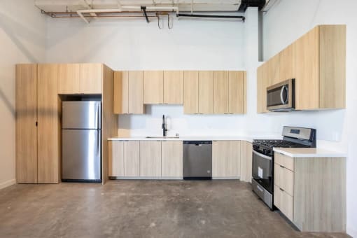 an empty kitchen with wooden cabinets and stainless steel appliances