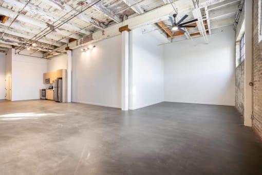 an empty room with white walls and a cement floor