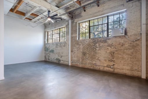 an empty room with a brick wall and a large window