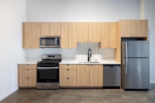 a kitchen with wooden cabinets and stainless steel appliances