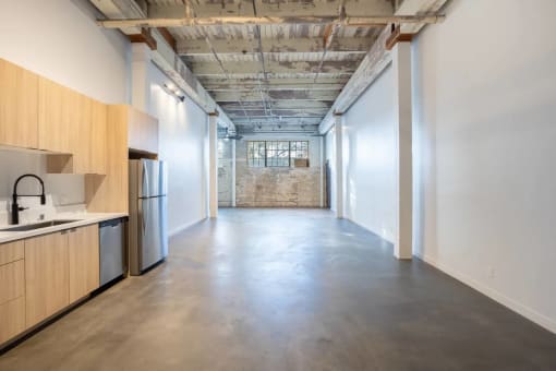 a kitchen with a sink and a refrigerator in a room with white walls