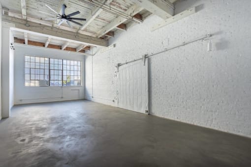 an empty room with a garage door and concrete floor
