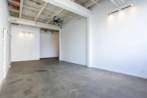 an empty room with white walls and a ceiling fan