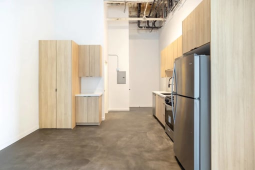 a kitchen with a refrigerator and cabinets in a room