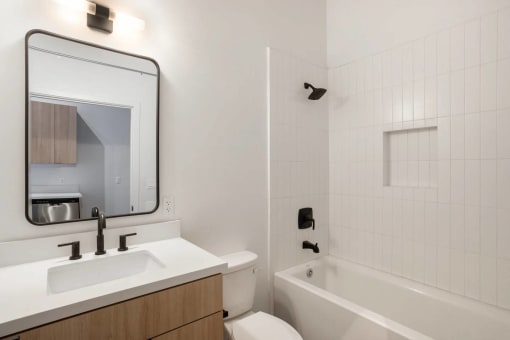 a bathroom with a sink and a tub and a mirror