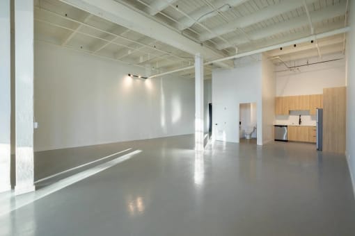 a large empty room with white walls and concrete floors