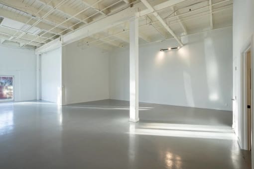 a large empty room with white walls and sunlight shining on the floor