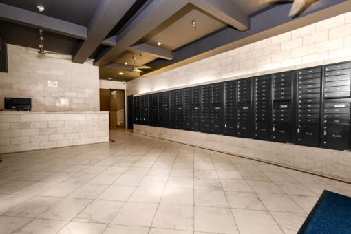 a large locker room in a gym with tile flooring and a white brick wall