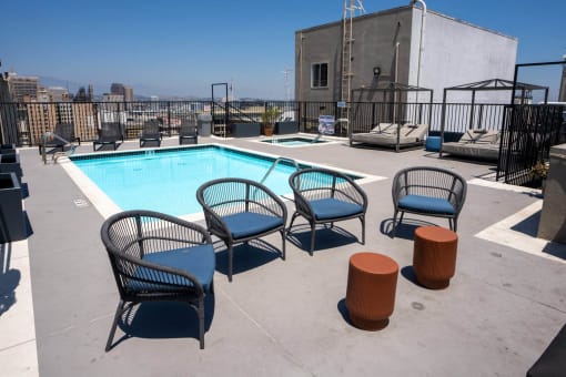 the pool at the top of a building with chairs