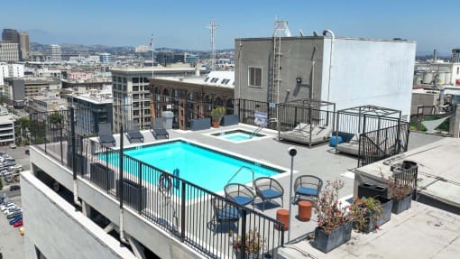 a swimming pool on the roof of a building with a city in the background
