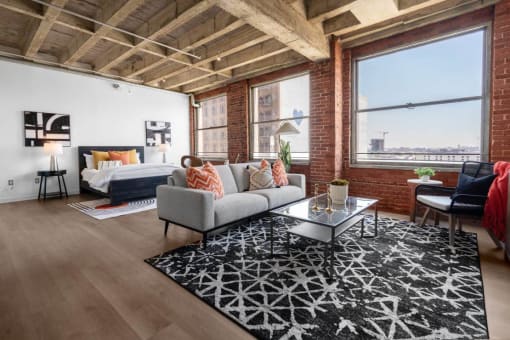 a living room with a couch and a bed in a loft