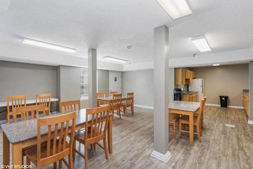 A room with wooden chairs and tables is shown.