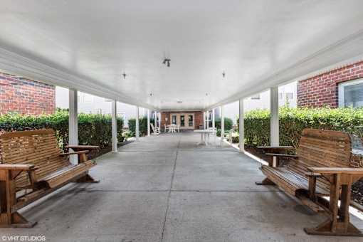 A long covered walkway with benches on either side.