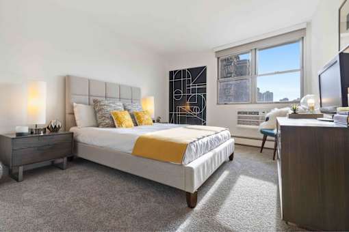 Large bedroom with plush carpeting and large windows