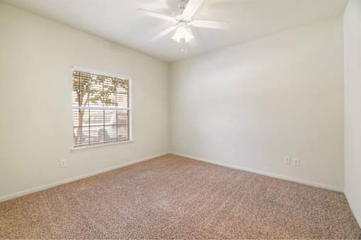 Bright bedroom with a ceiling fan at Stonehaven Apartments in Houston, TX