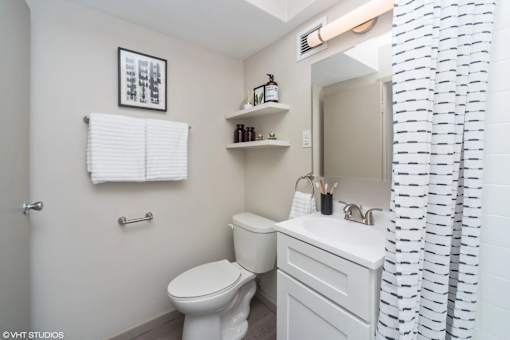Upgraded bathroom with bright lighting at Archer Tower in Denver, CO