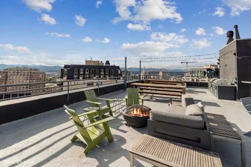 Rooftop patio with a fire pit and seating area at Archer Tower in Denver, CO