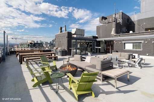Rooftop patio with a fire pit and seating area at Archer Tower in Denver, CO