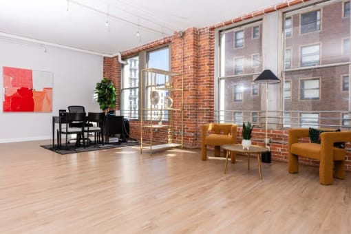 a living room with a brick wall and a wood floor