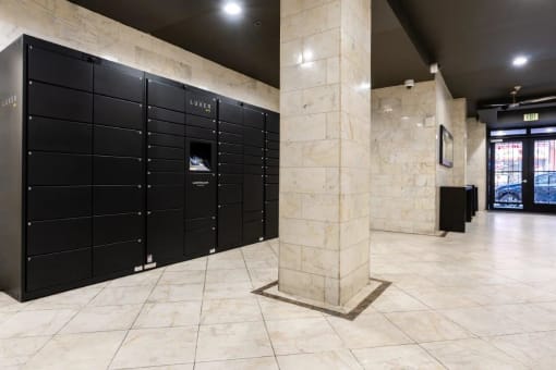 a row of black lockers in a building with a marble pillar