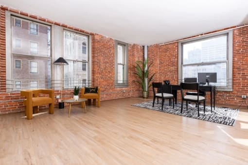 a living room with a piano and a brick wall