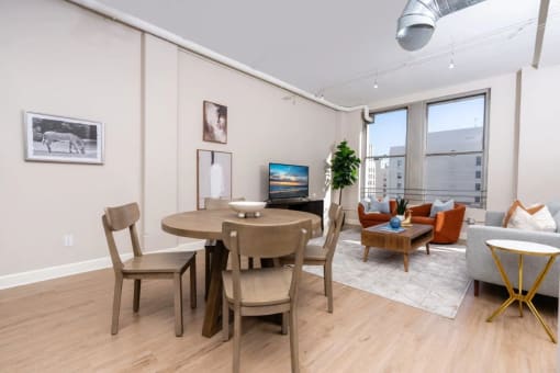 a living room and dining room with a table and chairs