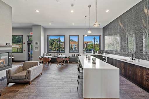 A modern kitchen with a large island and a dining table with chairs.