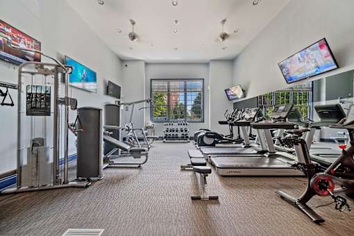 A gym with treadmills, exercise bikes, and other equipment.
