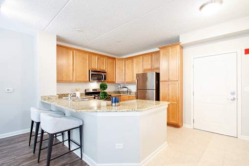 A kitchen with a white island and wooden cabinets.