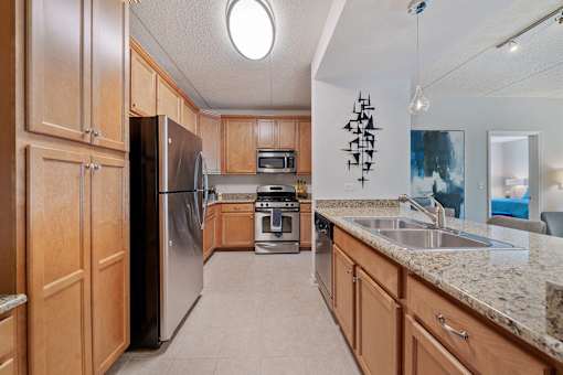 A kitchen with wooden cabinets and granite countertops.