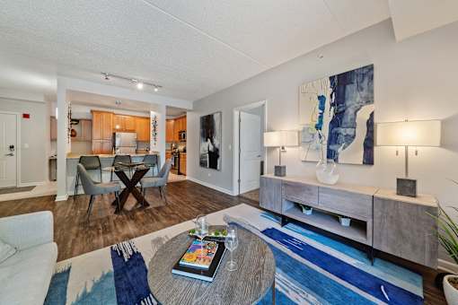 A living room with a white couch, a coffee table, and a blue rug.