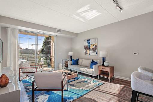 A living room with a couch, chairs, and a rug.
