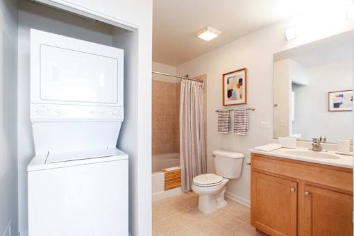 A white washing machine is in a small laundry room.