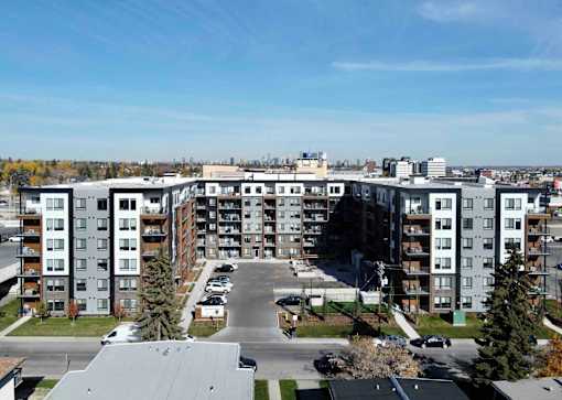 A large apartment complex with a parking lot in front.
