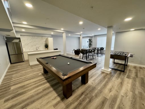 a game room with a pool table and a bar