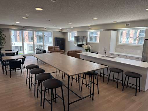 A modern kitchen with a long table and chairs.