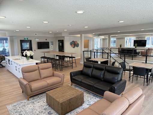 A living room with a black couch, brown armchair, and a wooden coffee table.