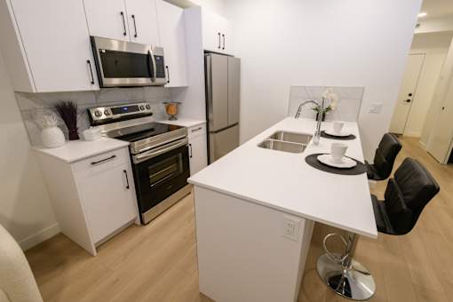 Contemporary kitchen at Douglas Place apartments with stainless steel appliances and quartz countertops