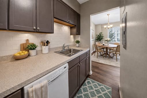 A kitchen with a white dishwasher and a white sink.