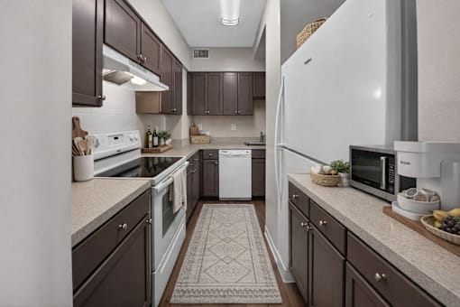 A kitchen with brown cabinets and a white refrigerator.