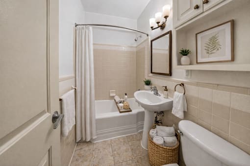 A bathroom with a tub, sink, and mirror.
